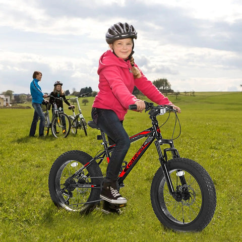 Child riding Fat Tire Kids Mountain Bike With 20X4 Inch Fat Tires Dual Disc Brakes Front Suspension 7 Speed All Terrain