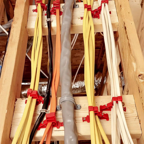 Lothee 200 Pack Red Cable Staples Clips With Steel Nails used to secure multiple data cables on wooden framing.
