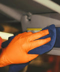 Orange nitrile disposable glove (XXL) being used with a blue cloth to wipe a car interior