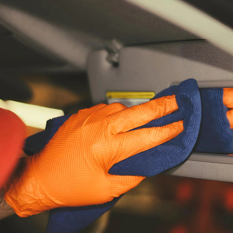 Orange nitrile disposable glove (XXL) being used with a blue cloth to wipe a car interior