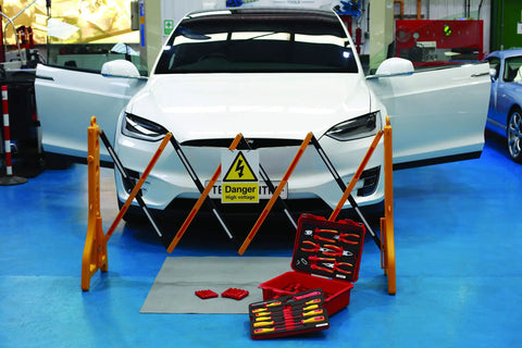VDE Tool Kit 50 Piece Pro Grade With Sixteen Three-Eighths Inch Drive Sockets displayed near an electric car on blue floor