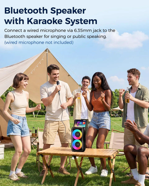 Group enjoying outdoor camping with Bluetooth Party Speaker With Colorful Lights and karaoke setup on a wooden table.