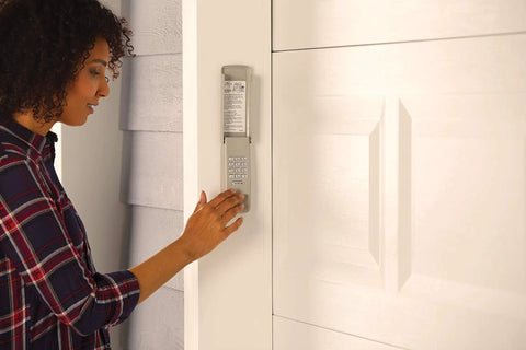 Person using wireless garage door keypad with illuminated backlit pad, no wiring required, super easy install, gray exterior keypad for home garage entry