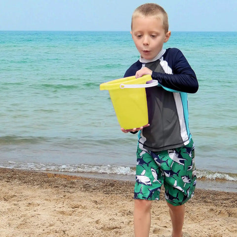 Child playing with yellow bucket from Six Pack Kids Beach Buckets And Shovels Set For Outdoor Summer Fun 7 Inch Large Sand Pails