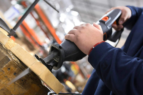 Worker using powerful 10 Amp Variable Speed Reciprocating Saw with 8 Position Pivoting Head and Twist Lock Blade Holder on wood