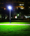 Ultra Bright Outdoor Solar Street Light With Dusk To Dawn Sensor illuminating a park area at night, highlighting green grass.