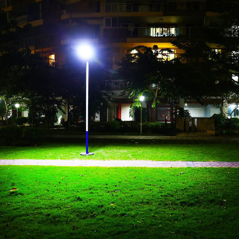 Ultra Bright Outdoor Solar Street Light With Dusk To Dawn Sensor illuminating a park area at night, highlighting green grass.