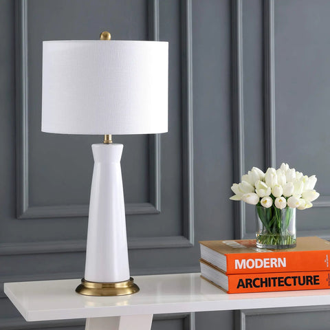 White And Brass Modern Ceramic Column Table Lamp With Gold Base, Sleek Bedside Light For Living Room Or Bedroom, White Linen Shade, LED Bulb Included, ETL Listed on table next to books and flowers.