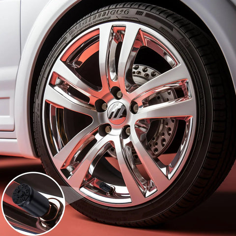 Close-up of a car wheel with a Bullet Shell Tire Valve Stem Caps Set In Aluminum Alloy, showcasing the sleek black cap on an air valve.