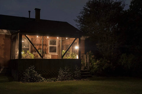 Backyard Bistro Style 24 Foot Outdoor String Lights With 12 Shatter Resistant Lifetime Bulbs illuminating a porch at night