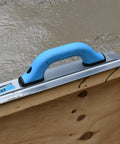 Pro-Grade Magnesium Concrete Float 3-1/8 x 16 In with beveled ends and rounded corners, on wooden slab edge