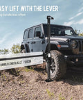 Beefy Seven Thousand Pound Off Road Recovery Jack With 60 Inch Reach Ratcheting Farm Jack lifting SUV on rough terrain