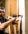 Man using Heavy Duty Brushless Cordless Drill Driver With No Fluff Quick Change Accessories And Real World Torque on drywall.