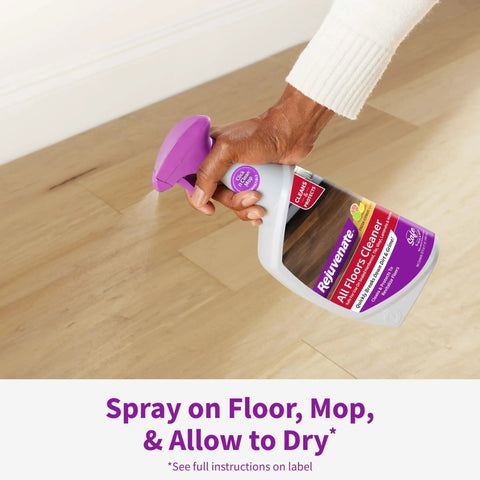 Hand spraying All Floors Cleaner Refill on sealed hardwood floor, demonstrating fresh citrus scent cleaning for dirt and grime removal.