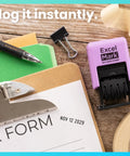 No Sweat Self Inking Date Stamp For Fast Shipping Receiving And Inventory Tracking Clean Black Ink With Easy Twist Dials For Expiration Checks And Reliable Violet Mount placed on a clipboard with paperwork.
