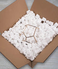 Heavy Duty White Packing Peanuts For Zero Stress Shipping Anti Static S Curve Half Cubic Foot Void Fill in a cardboard box.