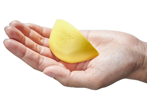 Hand holding a yellow memory foam shoe insert for big shoes fit unisex toe box fillers for wide feet or differing sizing.