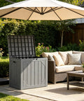 Gray massive 260 gallon outdoor storage box bench with open lid, situated on patio under umbrella, near outdoor sofa set.