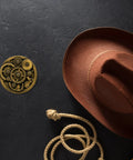 Handcrafted 3d Steampunk Gear Pewter Belt Buckle For Men And Women beside a brown cowboy hat and rope.