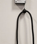 Top Shelf EV Charger Cord Retractor Keeps Your Charge Wire Locked Down And Beat Up Proof No Fuss Garage Setup Heavy Duty Wall Mount Bracket For J1772 Plugs Smooth Glide Action with black retractable cable holder mounted on wall.