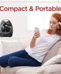 Compact Personal Desk Space Heater For Office And Home with fan and thermostat next to person relaxing on couch