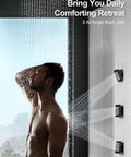 A person enjoying the GRANDJOY 20" LED Shower System with Handheld Spray, Matte Black, featuring three angle body jets.