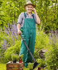 Gardener holding Triangle Garden Hoe With Sharp Blade For Digging, Weeding, Cutting And Loosening Soil in a lush garden setting.