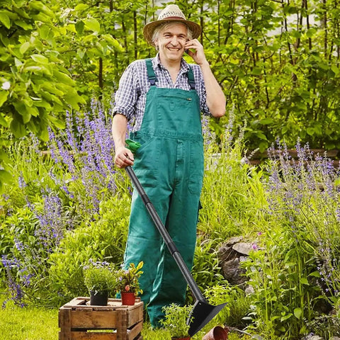 Gardener holding Triangle Garden Hoe With Sharp Blade For Digging, Weeding, Cutting And Loosening Soil in a lush garden setting.