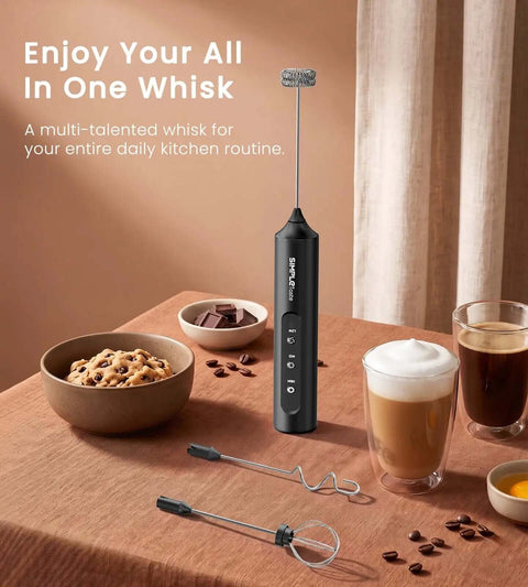 Rechargeable Handheld Milk Frother Electric Stainless Steel Whisk With Three Adjustable Speeds For Silky Coffee Foam And No Sweat Mixing Straight Up Kitchen Essential Gear on a kitchen table with cookies.