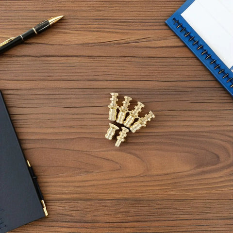 Metal Table Pins And Dowels Set For Furniture Joints And Desk Assembly on wooden surface with notebook and pen