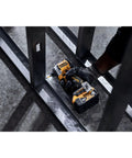 Compact 20V Max Brushless Cordless Impact Driver Kit With Battery And Charger Delivers Heavy Duty Muscle And Knockout Speed For The Daily Grind Featuring Smooth Variable Trigger And Blazing Bright Worksite Lighting in use on metal frame.