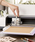 Front view of Cricut knife blade and drive housing installed in white Cricut Maker cutting machine