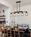 The Real Deal Five Light Farmhouse Chandelier With Slick Vintage Iron Frame And Crisp Clear Shades Giving Off Clean Modern Industrial Lighting Vibe For Dining Room Table Centerpiece, over a dining table.