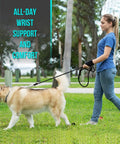 Person wearing All Day Comfort Wrist Wrap For Carpal Tunnel And Arthritis Relief walking a dog in a park.