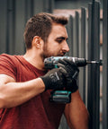 Man using drill wearing Ultra Thin PU Coated Work Gloves 60 Pairs With Excellent Grip Nylon Shell Black Polyurethane Coating Knit Wrist Cuff Bare Hand Feel For Light Duty Work