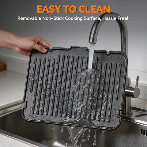Removable nonstick cooking surface for Bakers Friend 6-in-1 Indoor Grill and Electric Griddle Combo being rinsed under a faucet.