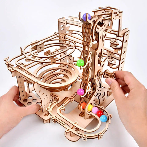 Hands assembling the Mechanical Marble Run Puzzle Kit With Chain Hoist 335 Pieces And 8 Marbles A DIY Wood Model Building Kit