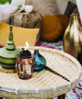 Adjustable Flame Glass Torch For Outdoor Decor Pink on woven table with decorative elements
