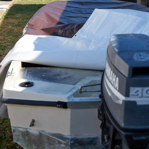 Boat covered by Tough As Nails Waterproof Reversible Tarp 12 By 24 Feet Thick 14 Mil Industrial Grade Tarp With Double Reinforced Corners