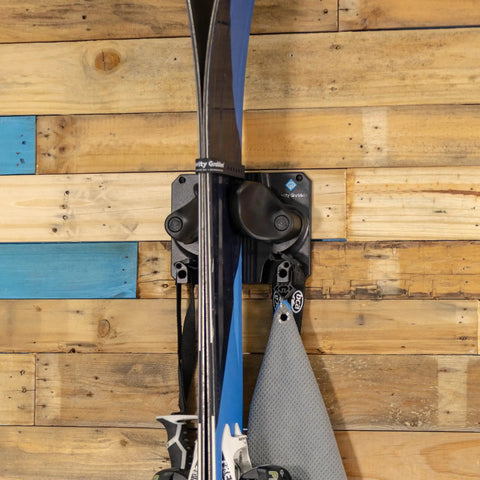 Rugged Black Gravity Lock Ski And Snowboard Wall Mount Rack Keeps Your Tip Rocker And Tail Lock Tight Premium Slip Resistant Grip for skis on wooden wall.