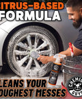 Man using Orange Degreaser Spray For Engines And More Heavy Duty All Purpose Cleaner Pro Strength Breaks Down Grease Oil And Grime For A Deep Clean Of Engines Tires Undercarriages And Tools 16 Oz on car wheel.