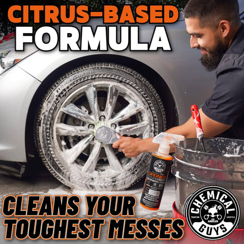 Man using Orange Degreaser Spray For Engines And More Heavy Duty All Purpose Cleaner Pro Strength Breaks Down Grease Oil And Grime For A Deep Clean Of Engines Tires Undercarriages And Tools 16 Oz on car wheel.
