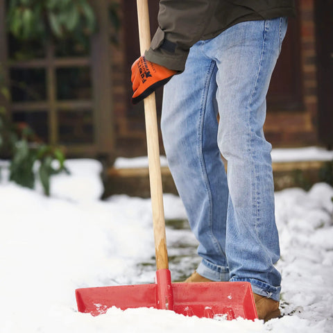 Person shoveling snow wearing waterproof insulated work gloves with thermal liner for cold weather, freezer ready work gear.