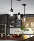 Black Pendant Lights For Kitchen Island, Modern Glass Hanging Fixture with adjustable drop cord above a kitchen island.