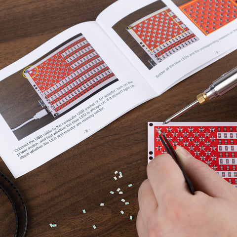 User assembling the American Flag DIY Soldering Project Kit With Compact Acrylic Shell For Hands On Electronics Learning on desk