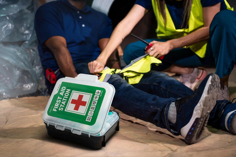 Portable first aid kit case with green label and red cross, white with black base.