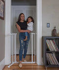 Mother holding child beside Everywhere Extra Tall and Wide Baby and Pet Gate for Doorways, Halls, and Stairs, Adjustable 28.75 to 39.75 Inch Wide, 36 Inch Tall, Pressure or Hardware Mounted, Easy In-Between Rooms Install, White Metal