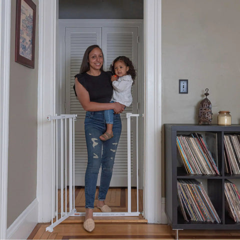 Mother holding child beside Everywhere Extra Tall and Wide Baby and Pet Gate for Doorways, Halls, and Stairs, Adjustable 28.75 to 39.75 Inch Wide, 36 Inch Tall, Pressure or Hardware Mounted, Easy In-Between Rooms Install, White Metal