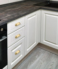 Brushed Matte Gold Brass Cabinet Drawer Pulls Pack Of Two And A Half Inch Center To Center Solid Knobs installed on white kitchen cabinets.