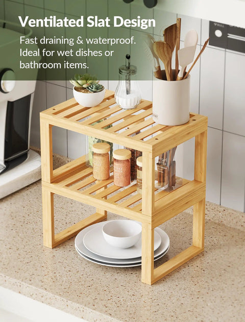 Heavy Duty Bamboo Cabinet Organizer Shelf Two Pack Stackable Kitchen Counter Rack Featuring Slatted Draining Surface To Air Out Dishes And Keep Counters Squeaky Clean. Two tier bamboo rack with slatted design, holding plates and jars.